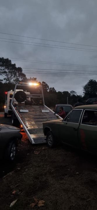 Plataforma do guincho inclinada para carregar um carro antigo ao anoitecer