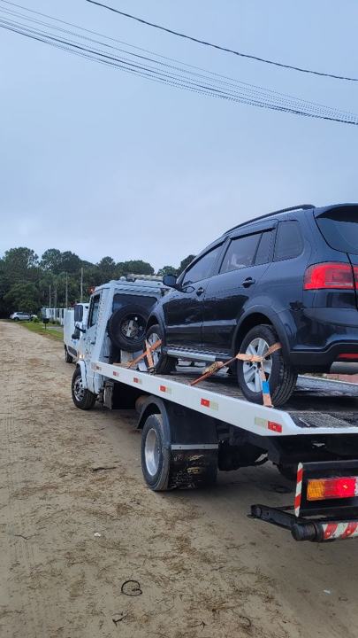 SUV preto sobre o guincho em dia de chuva