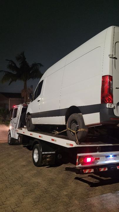 Van de carga branca sobre o guincho, à noite